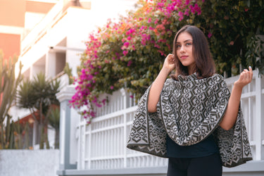 A Peruvian female model wearing a beautiful gray Peruvian Poncho with a unique intricate design